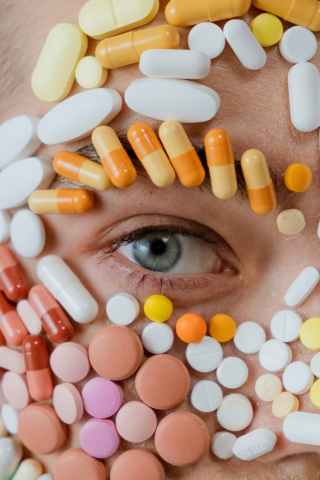 meth trafficking, meth, Synthetic Drug Surge, drug addiction, close up photo of assorted medicines surrounding a person s eye